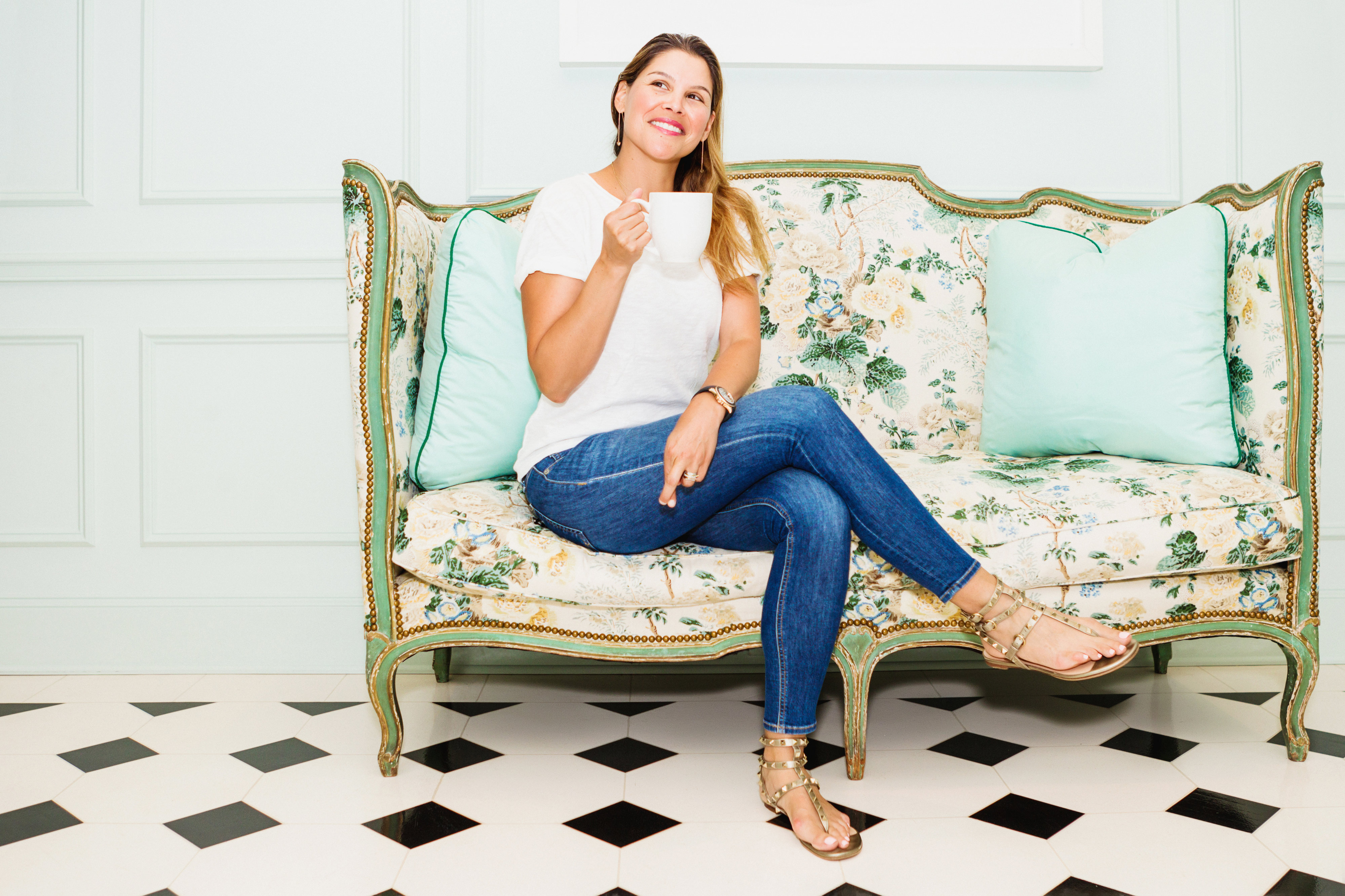 Switch 2 Pure founder Estela on a decorative couch drinking a cup of tea